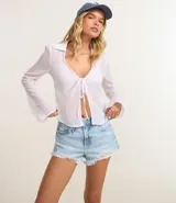 Short de jeans de mujer, modelo slim fit, color celeste claro con efecto desgastado y terminación deshilachada en el ruedo. Presenta tiro alto, trabillas para cinturón y cierre frontal tradicional.
