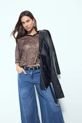 Remera de estilo deportivo con cuello en V y mangas cortas amplias. Presenta un diseño de rayas verticales en tonos marrones, blancos y líneas finas en fucsia, confeccionada en tejido de red.