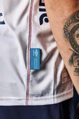 Camiseta de fútbol Umbro del Club Nacional de Football, modelo Home 2026. Diseño blanco con cuello en V, detalles en azul y rojo en el cuello y las mangas, y patrón en tejido jacquard. Incluye el logo de Umbro, el escudo del club y el sponsor antel en el pecho.