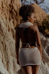 Top tejido al crochet color crudo, con capucha integrada y espalda descubierta.