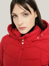 Campera acolchada Tommy Hilfiger color rojo con capucha, cierre de cremallera, bolsillos laterales con cremallera y logo bordado en el brazo.