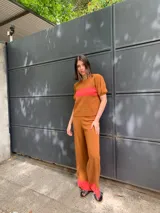 Sweater marrón de tejido de punto con una franja horizontal roja en el pecho y mangas cortas abullonadas.