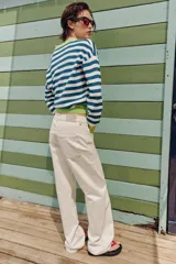 Sweater de punto a rayas horizontales en azul y blanco, con cuello polo verde lima, escote en V y detalles en verde lima en los puños y el borde inferior.