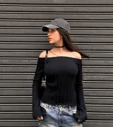 Sweater de punto trenzado color bordó, con escote estilo bote que deja los hombros al descubierto y mangas largas ligeramente acampanadas.