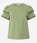 Blusa de manga corta color verde, con cuello redondo y detalles de terminación en efecto ganchillo en las mangas. Confeccionada en tejido de algodón con textura sutil.