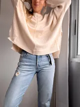 Sweater color crudo de tejido de punto, con cuello redondo y corte holgado.