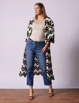 Cardigan largo de crochet color crudo con diseño de ondas en negro.