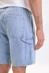 Bermuda de jean azul claro con lavado suave, bolsillos delanteros y traseros, y corte clásico de denim.