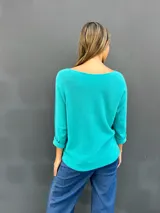 Sweater de punto color turquesa, con cuello redondo y mangas largas. Diseño básico y versátil de calce holgado.