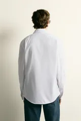 Camisa de corte regular fit confeccionada en tejido de algodón. Presenta cuello italiano, manga larga con puños abotonados y cierre frontal mediante botonadura.