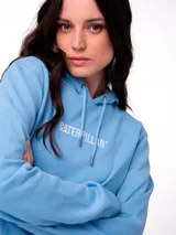 Buzo tipo canguro color celeste, con capucha y cordones ajustables. Presenta el logo de la marca bordado en el pecho, bolsillo frontal tipo canguro y puños y ruedo de punto acanalado.