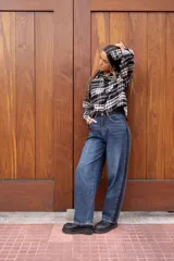 Pantalón de jean estilo mom fit, de tiro alto y corte amplio, con una franja lateral oscura en contraste.