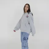 Canguro gris con capucha, bolsillo delantero tipo canguro y logo de la marca estampado en el pecho.