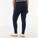 Pantalón de jean tipo skinny, color azul oscuro, con tiro muy alto y cierre frontal de botones expuestos.