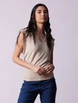 Buzo tejido en hilado fino color beige, con escote en V y sin mangas.