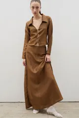 Falda larga de corte semi acampanado, confeccionada en tela con textura arrugada y acabado satinado.