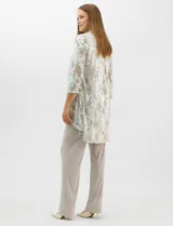 Conjunto de tres piezas compuesto por una musculosa de escote redondo, un cardigan abierto de mangas 3/4 y un pantalón de pierna ancha. La musculosa y el cardigan presentan un estampado abstracto con hilos metalizados, mientras que el pantalón es de color liso con cintura elástica.