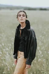 Campera oversize de cuero tostado con solapas y forro interno de corderito sintético azul marino, mangas anchas y detalles de costuras trenzadas.