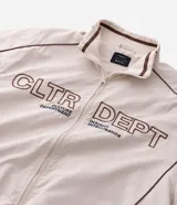 Campera de tejido técnico color beige con detalles de costuras en contraste color marrón. Presenta cuello alto, cierre frontal con cremallera, mangas largas con puños elásticos y estampa frontal con texto. Incluye un detalle bordado en la manga.