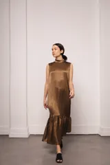 Vestido largo color ocre con estampado de cuadrados dorados, cuello alto y corte amplio. Incluye viso liso al tono.