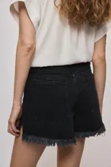 Short de jean blanco de tiro medio con silueta relajada y detalle de ruedo desflecado con flecos.