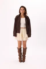 Minifalda marrón con volados de broderie, cintura elastizada con cordón ajustable y detalle de cuentas de madera.