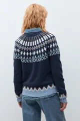Sweater de punto en color azul marino con diseño jacquard geométrico en tonos blanco, marrón y verde en el canesú, puños y ruedo. Presenta cuello redondo y mangas largas.
