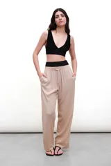 Top de bikini negro, estilo deportivo, con escote en V profundo y detalle de nudo o torcido en el centro del busto. Presenta tirantes anchos y un elástico ancho bajo el busto.