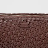 Bandolera marrón de cuero trenzado con correa ajustable.