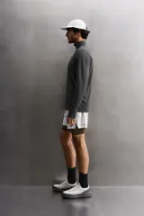 Camiseta de manga larga negra, confeccionada en tejido técnico ligero y elástico. Tiene cuello alto con cremallera, corte slim fit, bolsillo frontal con cremallera y puños con cinta a contraste.