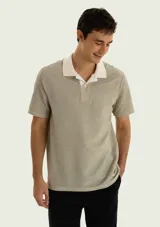 Chomba de manga corta con diseño a rayas finas en tonos beige y verde militar, cuello tipo polo y tapeta con botones.
