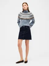 Buzo de punto con cuello alto, diseño estampado estilo fairisle con rayas horizontales y puntos en tonos tostado y blanco. Presenta mangas largas con puños acanalados y ruedo recto.