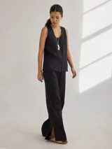 Pantalon de corte recto y tiro medio, confeccionado en lino, con cintura elastizada y tajos laterales en el ruedo.