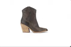 Bota corta estilo texana color negro, confeccionada en cuero, con taco foliado de suela natural de 6 cm.