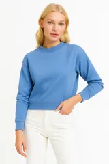 Buzo de cuello redondo y manga larga, con puños y ruedo acanalados. Diseño de corte holgado en color azul.