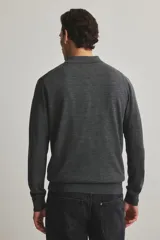 Remera polo de manga larga en punto de lana merino color gris oscuro, con cuello y tapeta de tres botones. Presenta remates acanalados en puños y bajo.