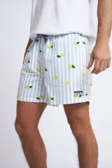 Short de baño con cintura elástica y cordón ajustable, confeccionado en tela ligera de secado rápido. Presenta un estampado botánico integral en tonos amarillos, blancos y azules, con dos bolsillos delanteros y uno posterior.
