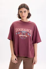 Camiseta boxy de manga corta color bordó con estampa frontal inspirada en el rock con leyendas "Rock & Roll" y "Rock Star World Tour".