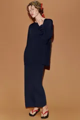 Jersey de punto fino con diseño oversize, cuello redondo y manga larga.