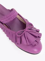 Ballerina Jules realizada en cuero vacuno liso, color morado. Presenta volados y una tira elástica sobre el empeine para un mejor ajuste, con un diseño plano y punta redondeada.