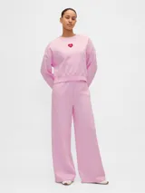 Pantalón deportivo de corte amplio y pierna ancha, color rosado, con cintura elástica y diseño holgado.
