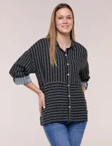 Camisa de rayón negra con patrón de líneas blancas. Presenta cuello camisero, cierre frontal con botones, mangas largas con puños vueltos y un diseño con corte horizontal que alterna líneas verticales en la parte superior y horizontales en la inferior.