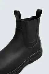 Bota tipo Chelsea de piel con acabado mate, diseño de horma redonda, elásticos laterales y suela track con volumen.