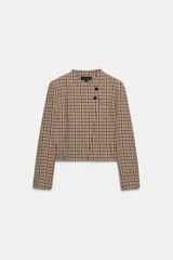 Blazer corto de cuello redondo y manga larga con estampado de cuadros. Presenta un diseño cruzado con cierre frontal de dos botones negros.
