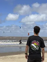 Remera color crema de algodón con estampa en la espalda de un paisaje playero con el texto "Chema Sure Chate et la mer".