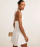 Vestido corto blanco de microfibra, con escote halter y espalda descubierta.