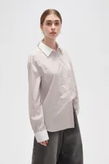 Camisa de lyocell con estampado de rayas verticales en tonos beige y blanco, corte holgado, cuello clásico y puños anchos en color blanco sólido.