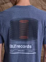 Remera de algodón color azul jaspeado, con estampa gráfica en la espalda que representa discos de vinilo y el logo B&T records.