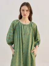 Vestido midi de diseño suelto con estampado geométrico en tonos marrones y beige, mangas 3/4 y cuello mao.