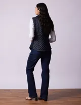 Chaleco capitoneado color beige, marca Gallery. Con abertura central con cierre, bolsillos delanteros con cierre, laterales en tejido elastizado y forro interno a tono.